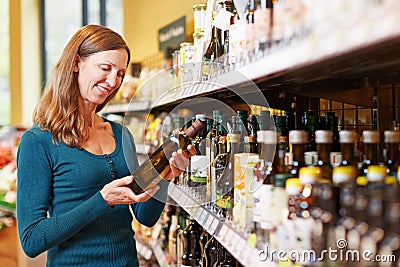 Woman buying bottle of olive oil