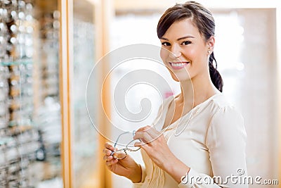 Woman Buying Glasses In Optician Store