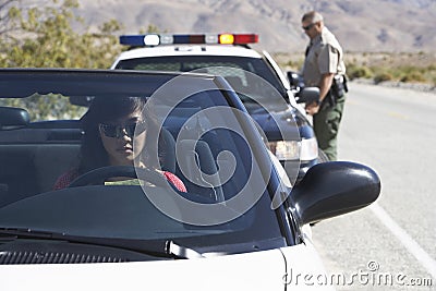 Woman In Car Being Pulled Over By Police Officer