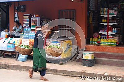 Woman is carrying a yoke at Luang Prabang City Loa