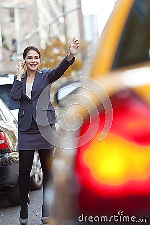 Woman on Cell Phone Hailing a Yellow Taxi Cab