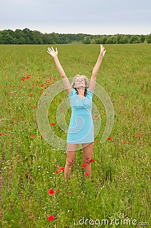 Woman cheering in poppy field