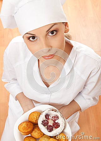 Woman chef holding tray of cookies.