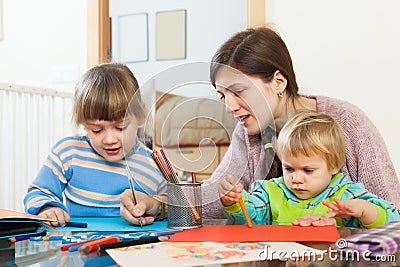 Woman and children together drawing with pencils