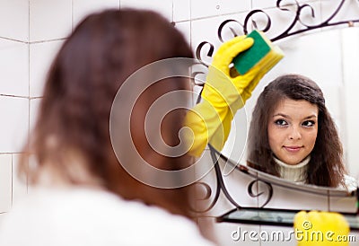 Woman cleans mirro