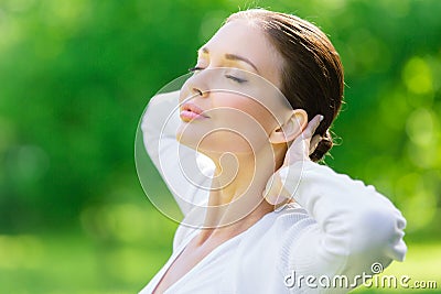 Woman with closed eyes puts hands behind head