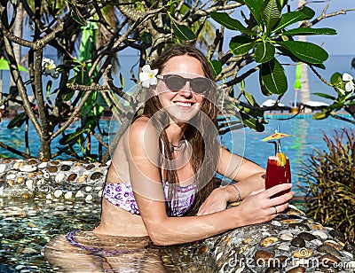 Woman with cocktail in pool