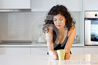 Woman with coffee or tea in the kitchen