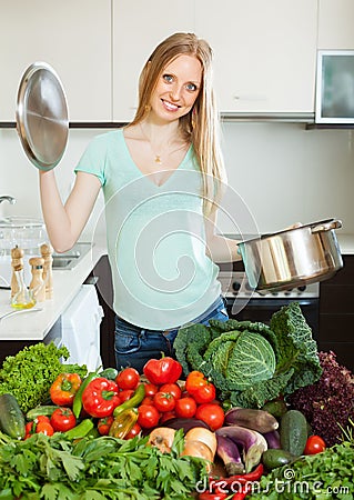 Woman cooking with pan and heap of vegetables
