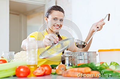 Woman cooking vegetarian food in saucepan