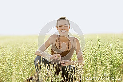 Woman Crouching In Field Of Grass