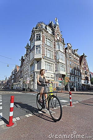 Woman cycling in Amsterdam Old Town.