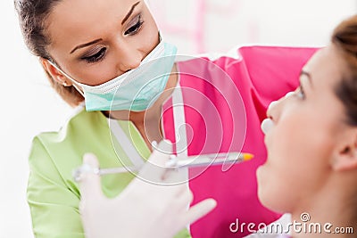 Woman dentist giving her patient an anesthesia injection
