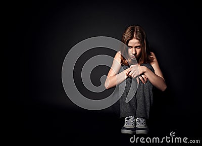 Woman in depression and despair crying on black dark