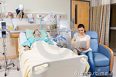 Woman With Digital Tablet Sitting By Patient