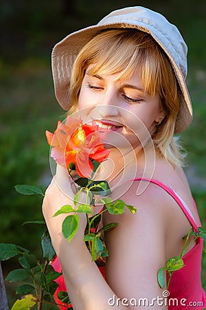 Woman doing garden work sniffing at the rose