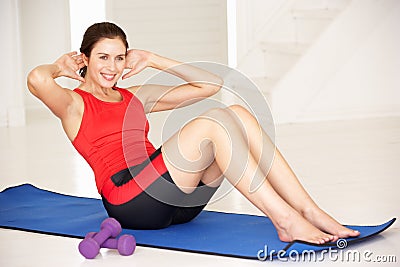 Woman doing sit-ups in home gym