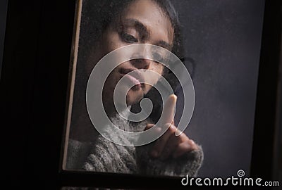 Woman drawing heart on wet window
