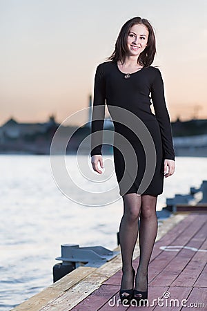 Woman in dress and high heels standing on waterfront