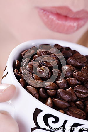 Woman drinking from coffee cup beans