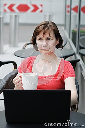 Woman drinking coffee in a outdoor cafe