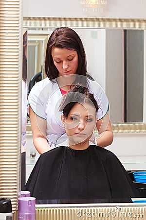 Woman dying hair in hairdressing beauty salon. By hairstylist.