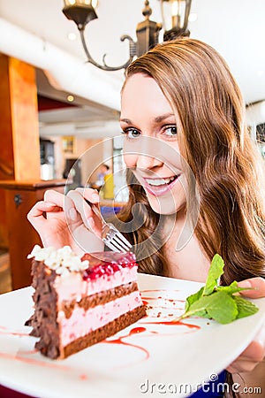 Woman eating cake at pastry shop cafe