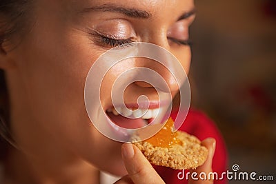 Woman eating cookie with orange jam