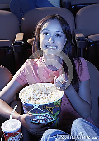 Woman Eating Popcorn While Watching Movie In Theater