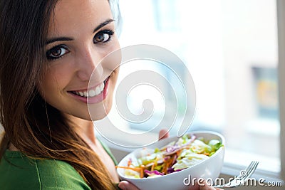 Woman eating salad. Portrait of beautiful smiling and happy Cauc