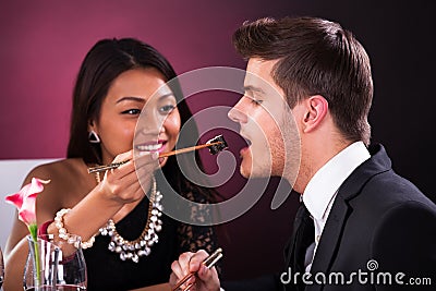 Woman feeding man in restaurant