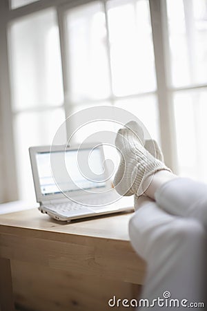 Woman With Feet On Desk Near Laptop