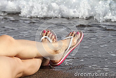 Woman Feet with flip flops on the Beach