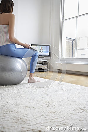 Woman On Fitness Ball Watching Television