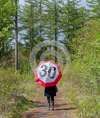 Woman in the forrest with a traffic sign umbrella