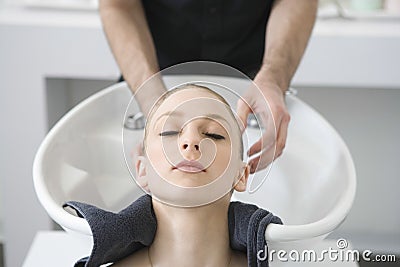 Woman Getting Hair Wash From Hairstylist In Salon