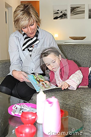 Woman and girl reading book