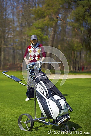 Woman at the golf range with trolley bag