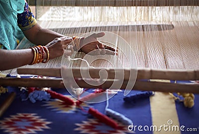 Woman hand weaving a carpet in India