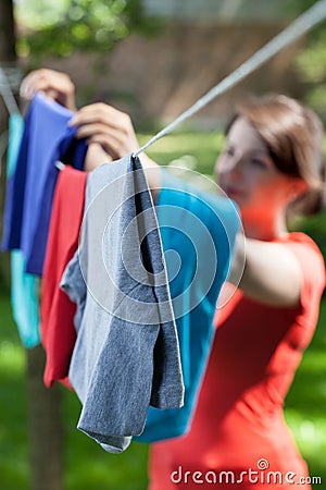 Woman hanging clothes on laundry line in garden