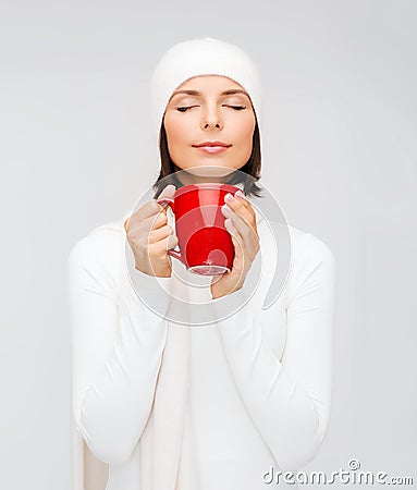 Woman in hat with red tea or coffee mug