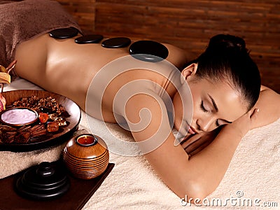 Woman having stone massage in spa salon