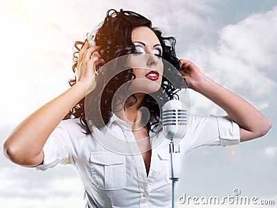 Woman with headphones and microphone over clouds