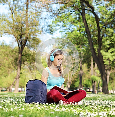 Woman with headphones studying in park