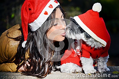 Woman with her dog with red christmas hats
