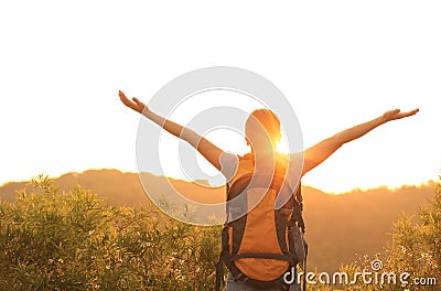 Woman hiker raised arms mountain top