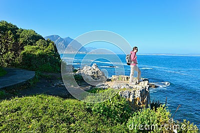 Woman hiking and looking at beautiful ocean view