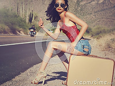 Woman hitching a ride on desert road