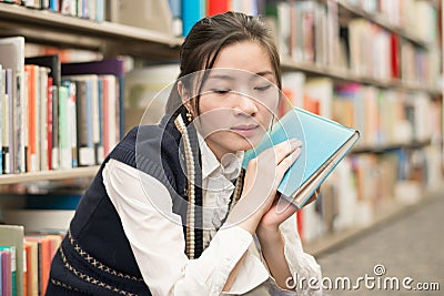 Woman holding a book near bookshelf