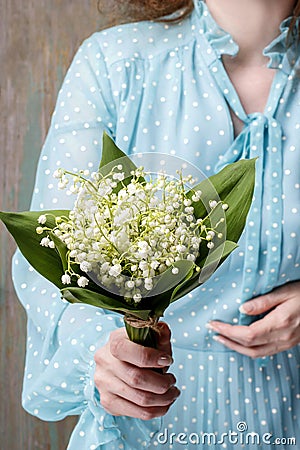 Woman holding bouquet of lily of the valley flowers